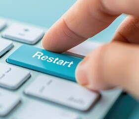 Wall Mural - finger pressing restart button on a teal keyboard close up shot of technology restarting