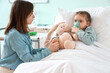 © Pixel-Shot - Woman and her ill little daughter with nebulizer in clinic