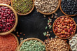 © CookShootsFood - Various legumes, overhead flat lay shot on a black background. Many different pulses, an assortment, with copy space, banner design
