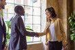 © Lomb - Business professionals shaking hands in modern office setting