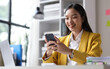 © Kainnika - Happy businesswoman using mobile phone and sending messages online on smartphone.