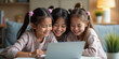© budistwn - Family of girls smil AIing and looking at a laptop. Generative