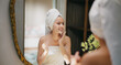 © Raushan_films - Indian young adult gen z woman lady teen girl female wrapped towel on head and body look mirror use fresh foam soap apply wet dry cheek take sink water hand splash on face do self skin care day home