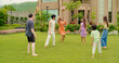 © Raushan_films - Indian happy family young man woman group play ball game throwing in air have fun joy enjoy outdoor park garden Playful cute teen girl son child kid boy with adult mom lady dad spend day time outside
