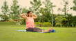 © Raushan_films - Indian mature adult older gen x woman lady sitting on yoga mat do stretch warm up asana in fresh air outdoor garden middle aged older female learn good self health care habit day time park