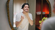 © Raushan_films - Indian Asian gen z young adult single happy man male guy smiling look mirror touch beard daily care routine feel proud good ready for new Joyful day enjoy indoor house