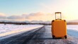 © RUENGWILAI - A solitary orange suitcase rests on a snow-covered road at sunset, surrounded by majestic mountains, depicting a serene travel moment in winter nature.