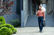 © Liubomir - Successful businessman walking through the city with phone in hands and business bag. Man in shirt typing text message and browsing social networks in full growth
