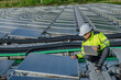 © reewungjunerr - Asian engineer working at Floating solar power plant,Renewable energy,Technician and investor solar panels checking the panels at solar energy installation