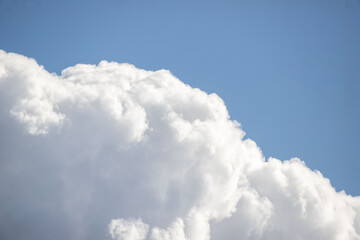 a fluffy white cloud in the sky with a blue sky background