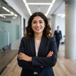 © Joa - Una mujer de negocios con los brazos cruzados en su oficina. Una mujer de negocios con poses confiables y traje.