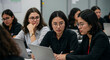 © Patrick - Asian students collaborating on laptop in modern classroom, Professional development and teamwork, Educational technology and diversity in higher education