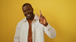 © Krakenimages.com - Young, handsome, african, american man smiling and making a peace sign over an isolated yellow background.