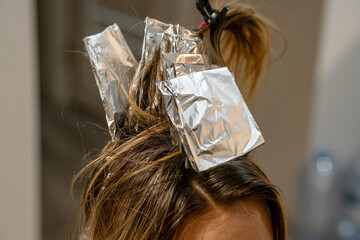 Poster - Hair coloring process in a salon using foil to create highlights for a stylish look