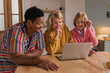© RVSTOCK - Senior Women Friends Gathering at Home. Three cheerful retired women enjoying friendly together in living room and chatting. Mature women use laptop computer typing on keyboard and pointing at screen