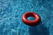 © olegganko - Bright Red Lifebuoy Floating in a Clear Swimming Pool on a Sunny Day