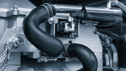Aufkleber - A close up of a car engine with a black hose. The hose is attached to the engine and is black in color