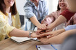 © New Africa - Unity concept. People holding hands together at wooden table indoors, closeup