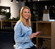 © Wavebreak Media - Professional woman using tablet in modern office, smiling confidently at camera