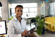 © Wavebreak Media - Smiling businessman using tablet in modern office during evening work session