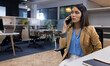 © Wavebreak Media - Businesswoman in office talking on smartphone, looking focused and attentive, copy space
