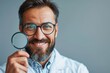 © auttawit - Man with glasses is holding a magnifying glass and smiling
