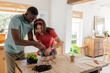 © Wavebreak Media - African American man and woman planting seedlings together, gardening at home