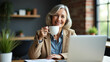© HaJung - Smiling Mature Woman Enjoying Coffee While Working from Home: A Modern E-Learning Experience