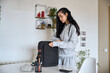 © alvaro - Young woman preparing backpack at home office