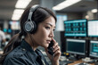 © polack - Face of Asian female police officer in a call center 911 operator talking on the phone in a busy police office environment