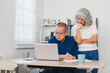 © PRIME STOCK LAB - Senior couple reviewing pension savings on laptop at home, focused and thoughtful in bright living room setting.