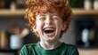 © Nataliia_Trushchenko - Young boy with red hair is smiling and laughing. He is wearing a green shirt. Scene is happy and joyful
