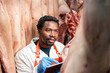 © littlewolf1989 - Experienced meat industry supervisor checking quality of pork meat in slaughterhouse.
