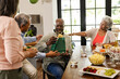 © Wavebreak Media - Receiving gift at diverse senior friends party, african american man smiling, at home