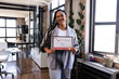 © Wavebreak Media - Proud woman holding achievement certificate in modern office, smiling confidently
