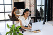 © Wavebreak Media - Asian woman working on laptop in modern office, smiling and focused