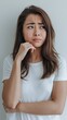 © Wix - Image of young asian brunette woman in white tshirt smirk and look with doubt hesitating standing agnst white background copy space
