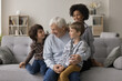 © fizkes - Visiting grandpa. Loving senior grandfather meet little multiethnic grandsons gather grandkids group at cozy home hug small brothers on couch enjoy talking sharing sweet moments at happy family time