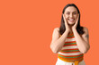 © Pixel-Shot - Smiling young woman on orange background