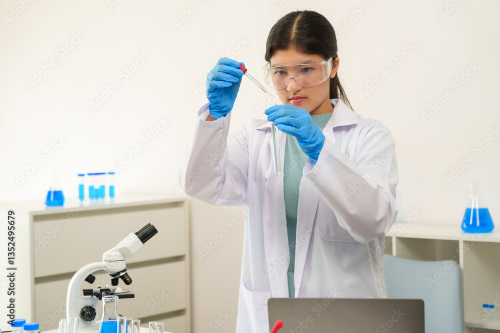 Teenage caucasian girl in lab coat wearing safety goggles and gloves ...