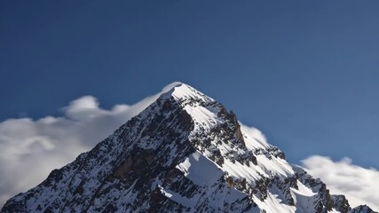 Wall Mural - Snow-covered mountain peak under clear blue sky, majestic landscape view