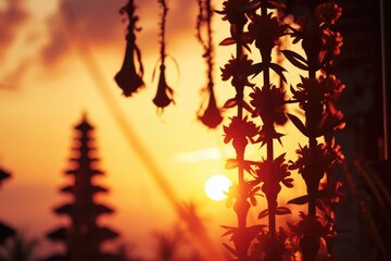 Wall Mural - silhouetted flowers and a balinese temple at sunset, a vibrant orange hue.