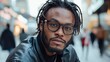 ©  Shomixer - A fashionable man with glasses confidently poses in an urban environment, highlighting personality and style, ideal for lifestyle and fashion stock photography.