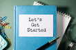 © ARAMYAN - White notebook with the text LET IS GET STARTED on the table