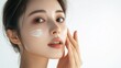 © Zue - asian model woman face applies light white cream on her face