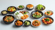 © Unic - Assortment of Korean Dishes Featuring Kimchi Rice and Vegetables in a Variety of Colorful Bowls on a White Background