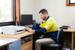 © Austockphoto - Male tradie looking at bills in home office
