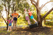 © Austockphoto - Dad playing with children in backyard on tyre swing in the afternoon