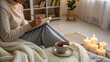 © Yelloone - A cozy indoor scene featuring a person journaling with a cup of tea and candles, creating a warm, peaceful atmosphere.