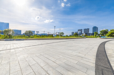 empty brick floor and cityscape with modern buildings in the background